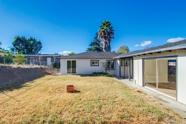 rear view of property featuring a lawn