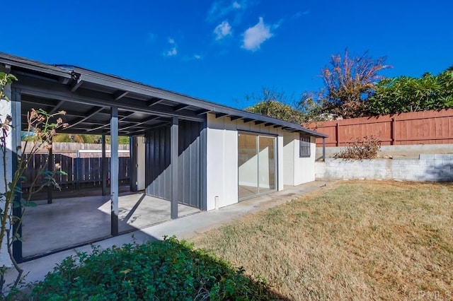 rear view of property featuring a patio and a yard