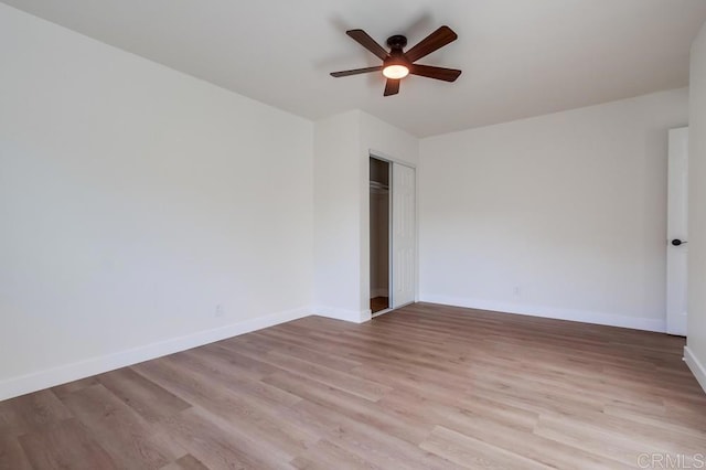 unfurnished bedroom with ceiling fan, light hardwood / wood-style flooring, and a closet