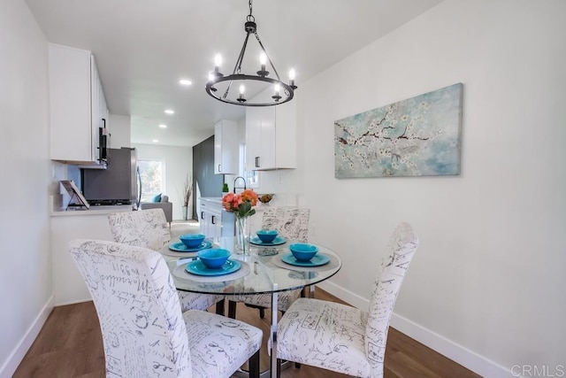 dining area with dark hardwood / wood-style flooring and a chandelier