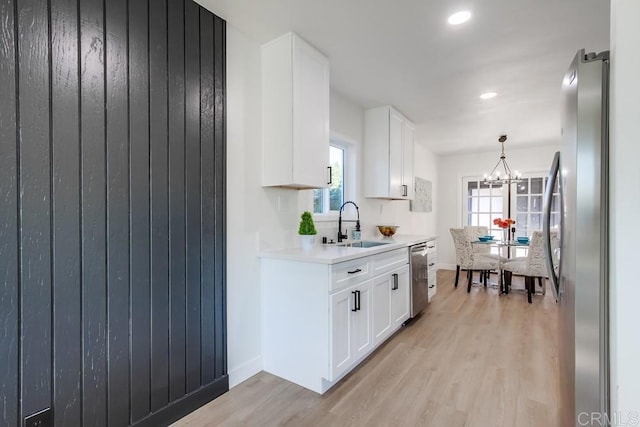 kitchen featuring sink, white cabinets, light hardwood / wood-style flooring, and stainless steel appliances