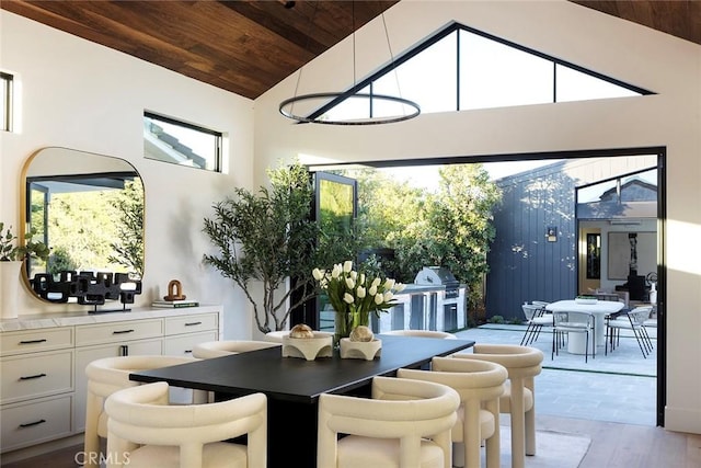 dining room featuring light hardwood / wood-style floors, high vaulted ceiling, and wood ceiling