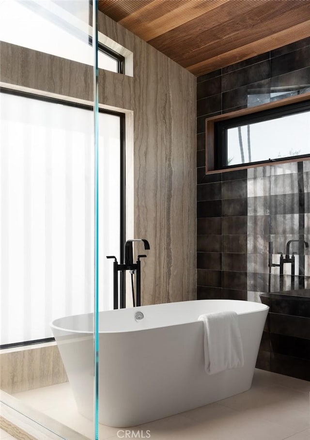 bathroom with a bath, wood ceiling, and tile patterned floors