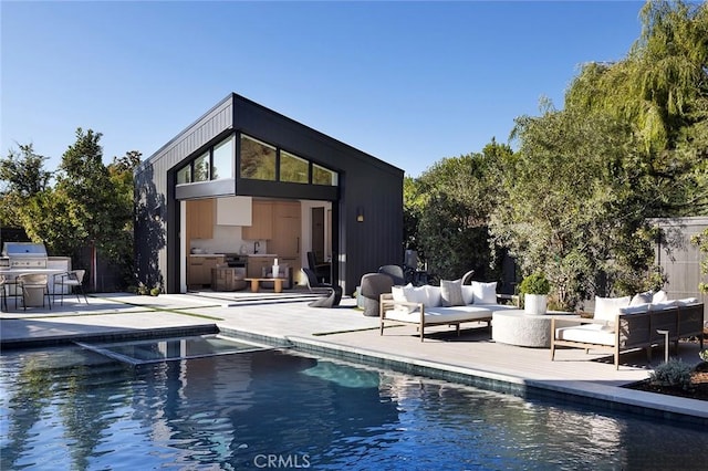 rear view of property featuring an outdoor kitchen, outdoor lounge area, and a patio