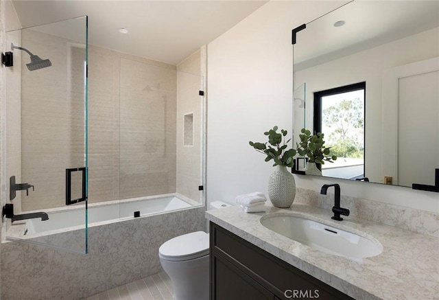 full bathroom featuring toilet, tile patterned floors, tiled shower / bath, and vanity