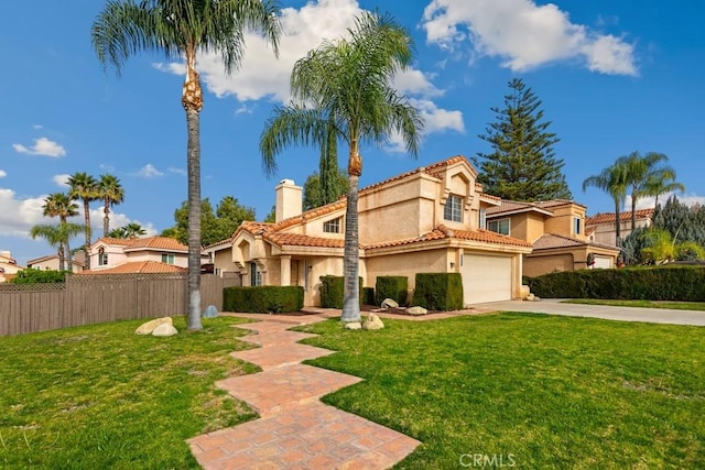 mediterranean / spanish-style house featuring a garage and a front yard