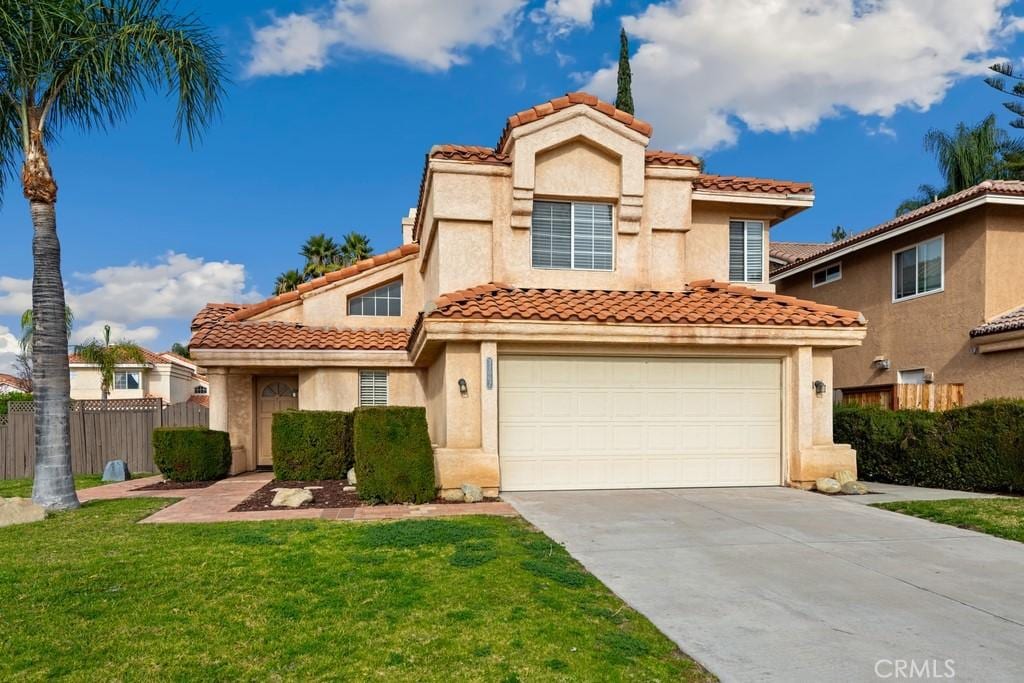 mediterranean / spanish-style house featuring a front lawn and a garage