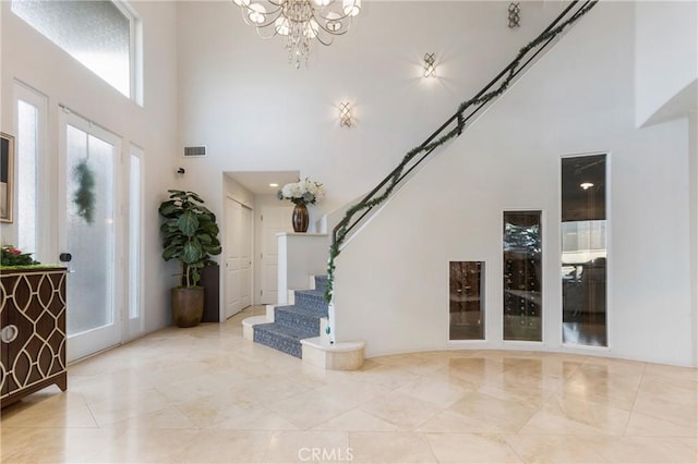 foyer with a high ceiling and a notable chandelier