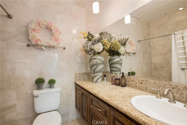 bathroom featuring tile walls, toilet, and vanity