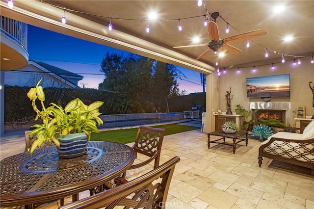 view of patio with ceiling fan and an outdoor fireplace