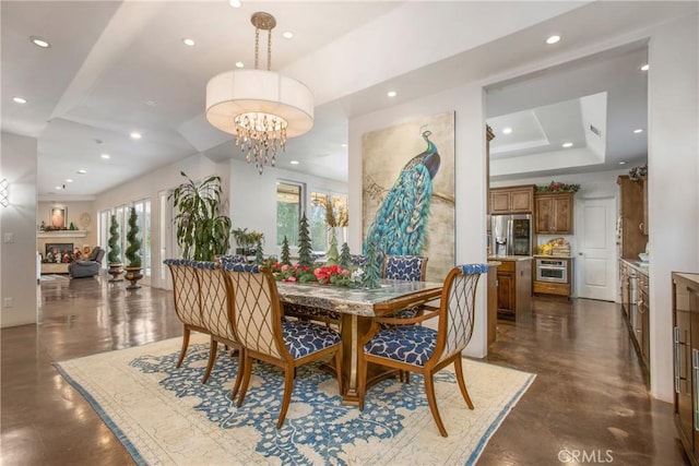 dining space with a raised ceiling and an inviting chandelier