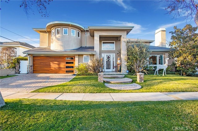 view of front of property featuring a front yard and a garage