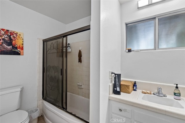 full bathroom with toilet, enclosed tub / shower combo, and vanity