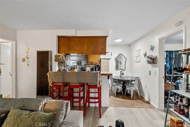 kitchen with light hardwood / wood-style floors and a kitchen breakfast bar