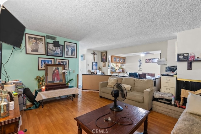 living room featuring a textured ceiling and light wood-type flooring