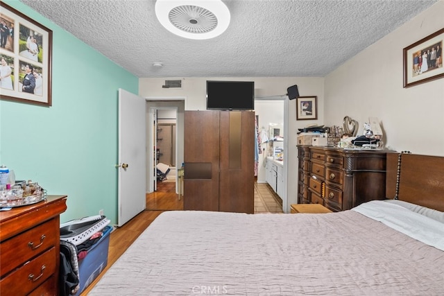 bedroom featuring a textured ceiling and light wood-type flooring