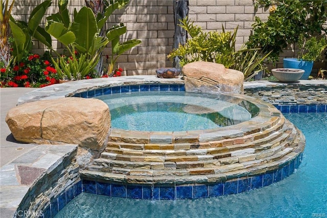 view of swimming pool featuring an in ground hot tub