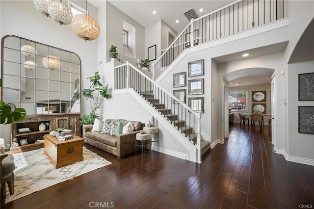 interior space featuring a towering ceiling and dark hardwood / wood-style flooring