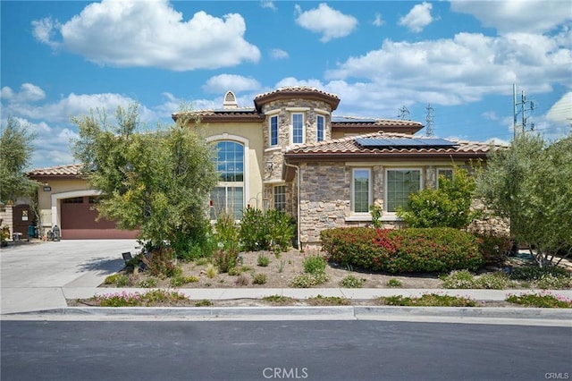 mediterranean / spanish-style home with a garage and solar panels