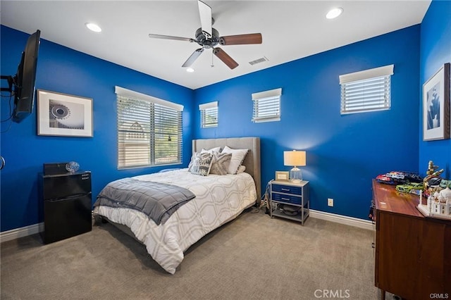 carpeted bedroom featuring black fridge and ceiling fan