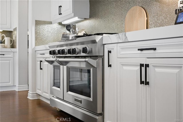 kitchen with white cabinetry, double oven range, dark wood-type flooring, and backsplash