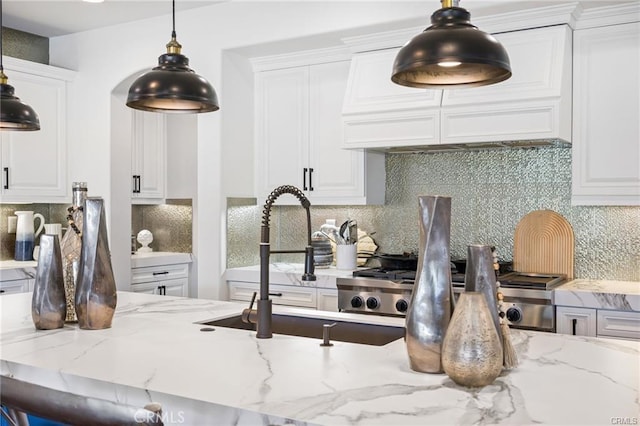 kitchen featuring light stone countertops, white cabinets, and decorative backsplash