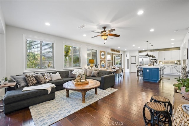 living room featuring ceiling fan and dark hardwood / wood-style flooring