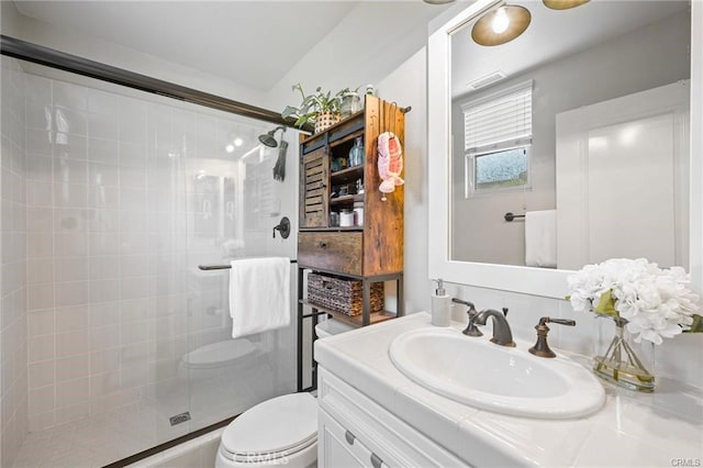 bathroom featuring walk in shower, vanity, and toilet