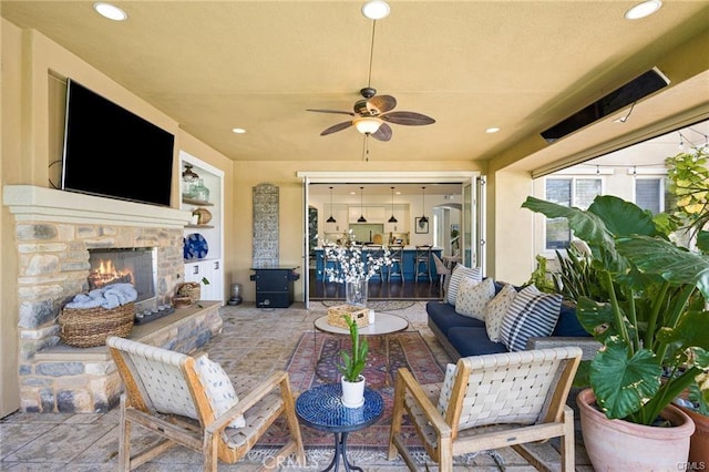 view of patio / terrace featuring ceiling fan and an outdoor stone fireplace