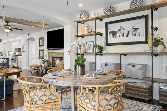 dining space with beamed ceiling, ceiling fan, and dark hardwood / wood-style flooring