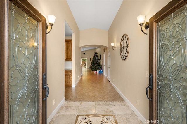 entryway featuring arched walkways and baseboards