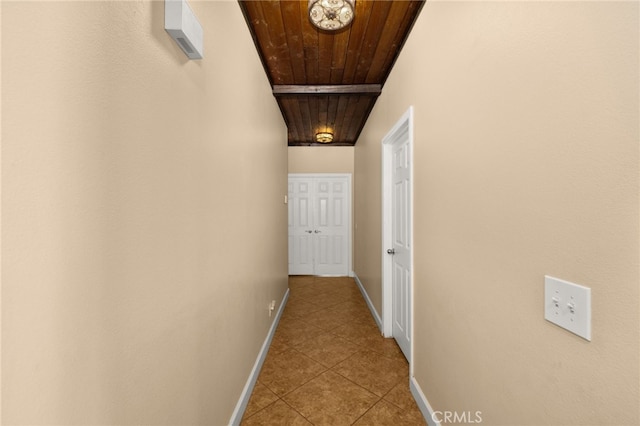 hallway featuring tile patterned flooring, wood ceiling, and baseboards