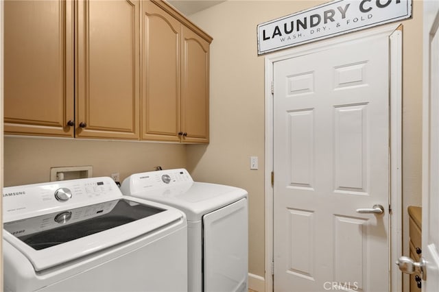 laundry room featuring washing machine and clothes dryer and cabinet space