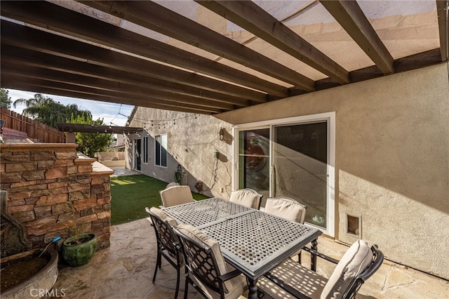 view of patio featuring outdoor dining area and fence