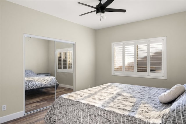 bedroom featuring ceiling fan, a closet, wood finished floors, and baseboards