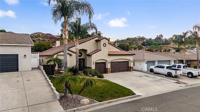 view of front of home featuring a garage, a tile roof, concrete driveway, and stucco siding