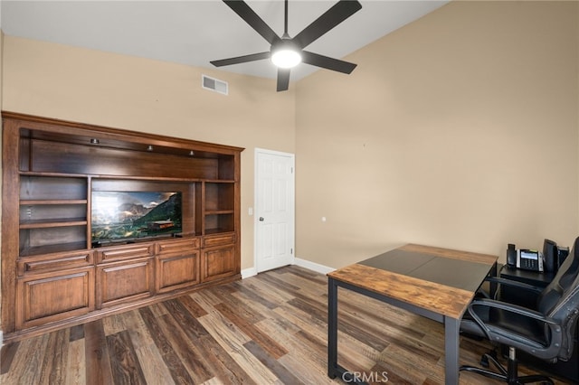 office featuring lofted ceiling, visible vents, baseboards, a ceiling fan, and dark wood finished floors