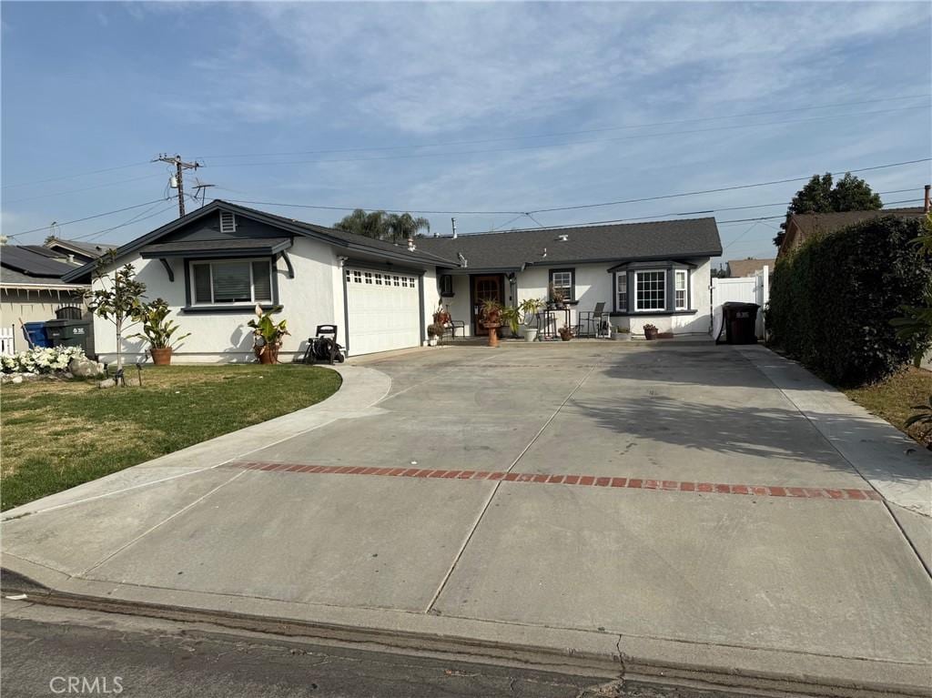 single story home featuring a garage and a front yard