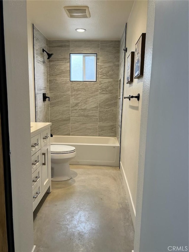 full bathroom featuring toilet, concrete floors, tiled shower / bath, a textured ceiling, and vanity