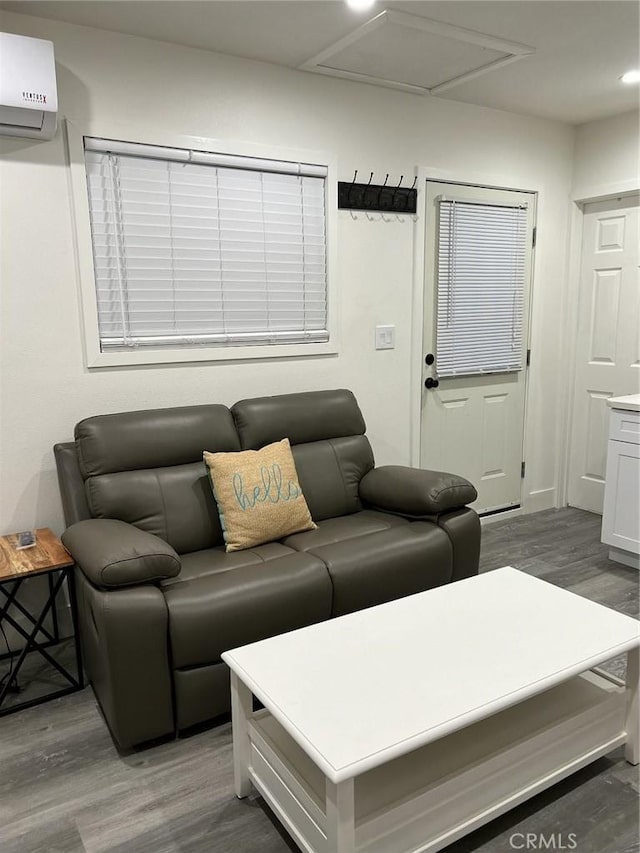 living room featuring dark wood-type flooring and a wall mounted air conditioner