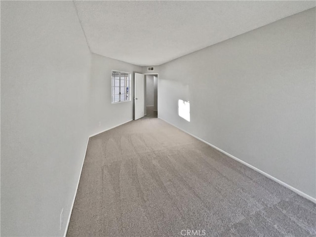 empty room with a textured ceiling and carpet floors