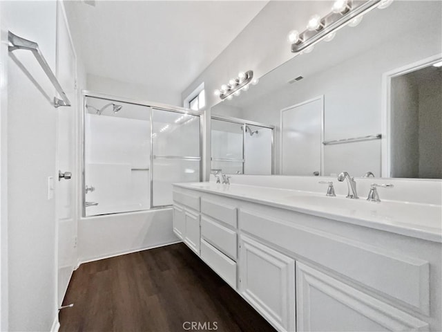 bathroom with vanity, shower / bath combination with glass door, and hardwood / wood-style flooring