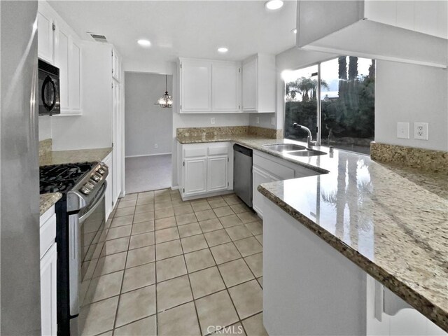 kitchen with light stone countertops, sink, white cabinets, and appliances with stainless steel finishes