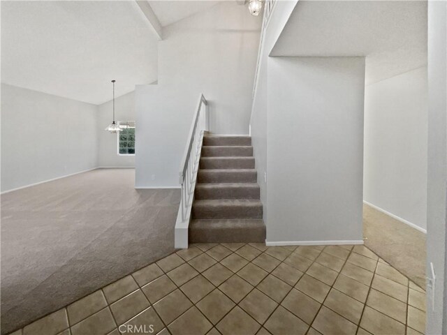 stairway featuring carpet floors and lofted ceiling