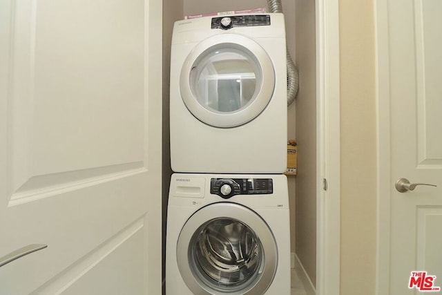 clothes washing area featuring stacked washer / dryer