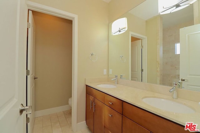 bathroom with toilet, tile patterned flooring, and vanity