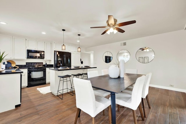 dining area with ceiling fan and dark hardwood / wood-style floors