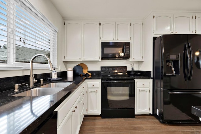 kitchen featuring white cabinetry, sink, and black appliances