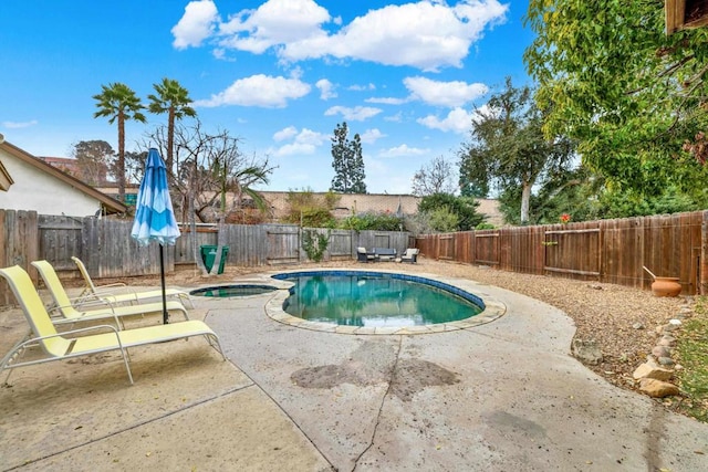 view of pool featuring a patio and an in ground hot tub