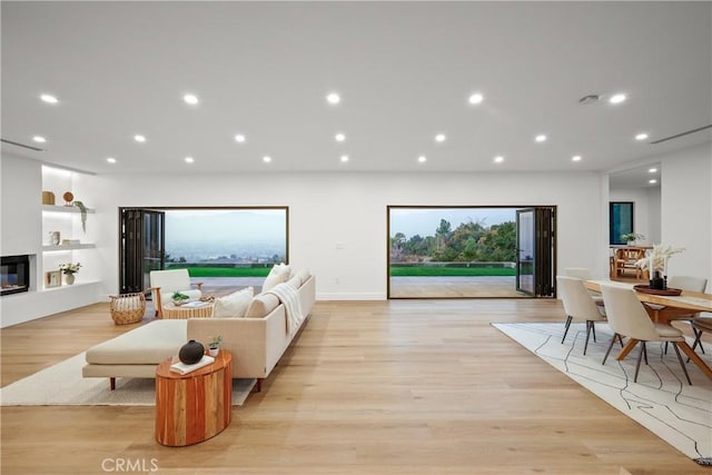 living room featuring built in features and light wood-type flooring